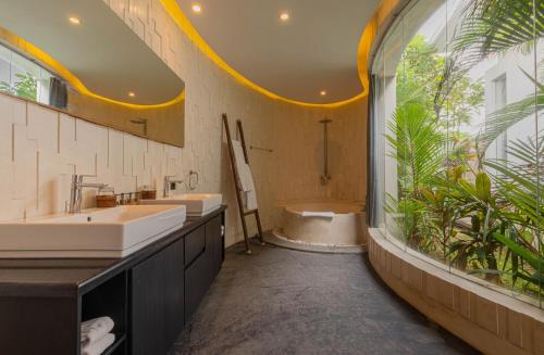 ein Badezimmer mit zwei Waschbecken und einem großen Fenster in der Unterkunft Taman Mesari Luxury Villas-Seminyak in Seminyak