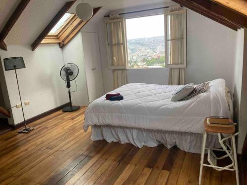 - une chambre avec un lit, une fenêtre et un ventilateur dans l'établissement Loft privado Cerro Alegre, estilo Buhardilla., à Valparaíso