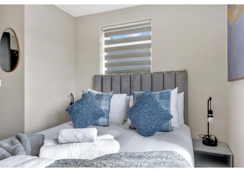 - une chambre avec un grand lit et des oreillers bleus dans l'établissement A Place to Dream: Airy Studio in Serene Locale, à Londres