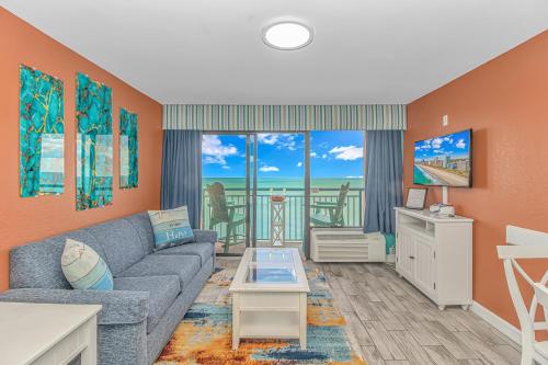 a living room with a couch and a view of the ocean at Direct Oceanfront 1 bedroom Condo - Surf's Up Oceanfront Oasis 1416 in Myrtle Beach