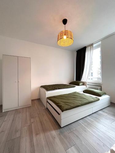 a bedroom with two beds and a chandelier at 93qm-4 Rooms-WiFi-City Centre in Kassel