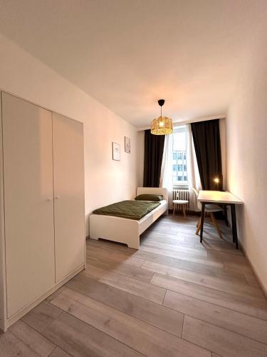 93qm-4 Rooms-WiFi-City Centre في كاسيل: غرفة نوم بسرير وطاولة ونافذة