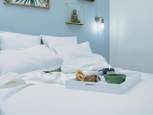 een wit bed met witte kussens en een dienblad met eten bij Élite Suite Home in Termoli
