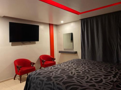 ein Hotelzimmer mit einem Bett und zwei roten Stühlen in der Unterkunft Smae in Mexiko-Stadt