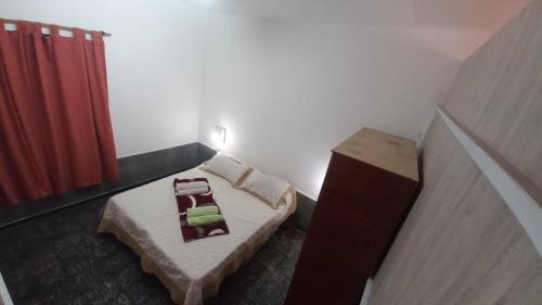 um pequeno quarto com uma cama e uma cortina vermelha em Esquina La Argentina em San Luis