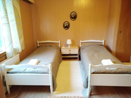 2 camas en una habitación pequeña con ventana en Former Hotel Restaurant Kannonkrouvi, en Kannonkoski
