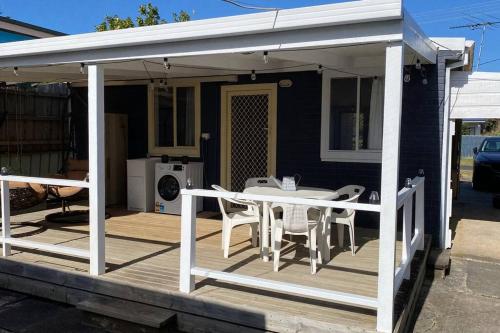 une terrasse couverte avec une table et des chaises sur une maison dans l'établissement Rosebud Beach Cottage, à Rosebud