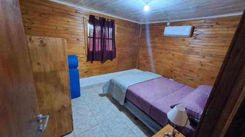 a bedroom with a bed and a tub in a wooden room at Cabañas Brisa Bonita Misiones in Posadas