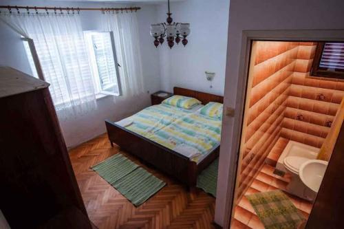 une chambre avec un lit avec une tête de lit en bois dans l'établissement Apartment in Barbat - Insel Rab 16122, à Barbat na Rabu