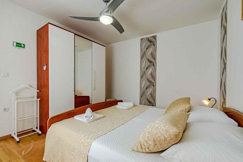 Un dormitorio con una cama con ventilador de techo. en Apartment in Prizba - Insel Korcula 6404, en Prizba