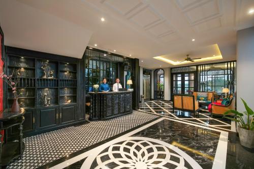 two people standing at a bar in a lobby at Serene Nature Hotel & Spa in Hoi An