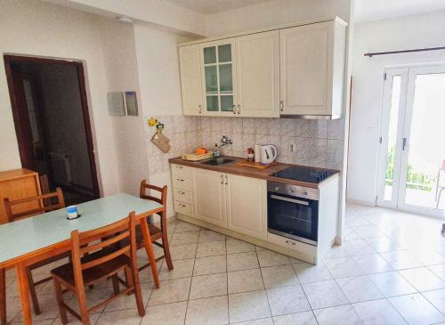 a kitchen with white cabinets and a table with chairs at Apartments in Vinisce 7372 in Vinišće