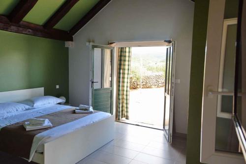 een slaapkamer met een bed en een glazen schuifdeur bij Holiday home in Pucisca/Insel Brac 6050 in Pučišća