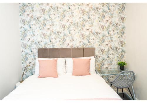 a bedroom with a white bed with pink pillows at Fresh and Relaxing 1 BD Flat in Manchester