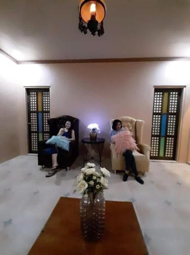 two women sitting in chairs in a living room at Shawn's Transient House at New Clark City in Calingcuan