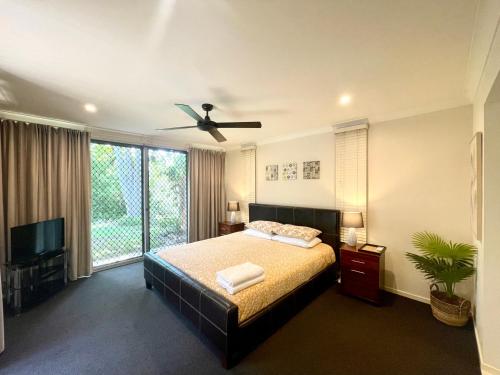a bedroom with a bed and a ceiling fan at Spacious Hideaway Retreat, Brookfield, Brisbane in Brisbane