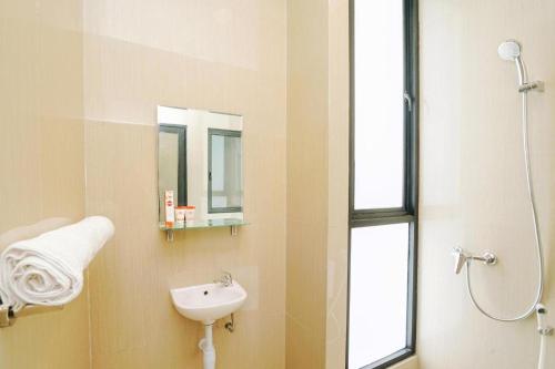 a bathroom with a sink and a mirror at The Colins Hotel in Surabaya