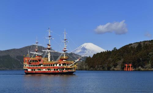 a large boat in the water with a mountain in the background at 北欧風のお部屋箱根神社参拝や駅伝観戦 芦ノ湖 箱根観光に最適な花火が見える 海賊船 コンビニ徒歩圏102 in Hakone
