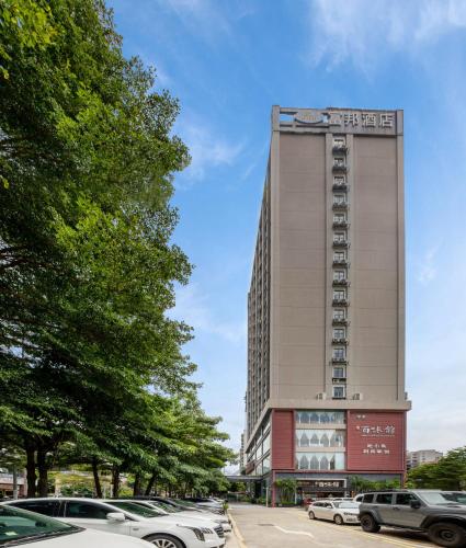 a tall building with cars parked in a parking lot at Fortune Land Shenzhen in Shenzhen