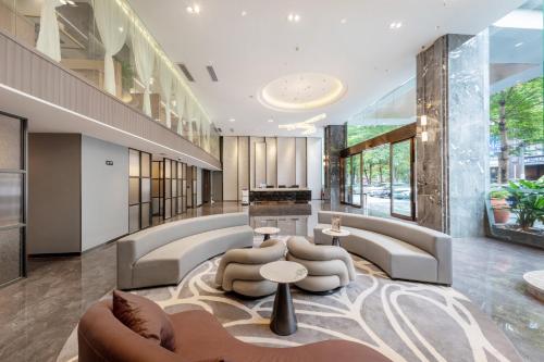 a lobby of a building with couches and tables at Fortune Land Shenzhen in Shenzhen