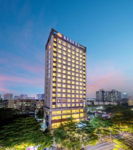 a tall building with lights on in a city at Fortune Land Shenzhen in Shenzhen