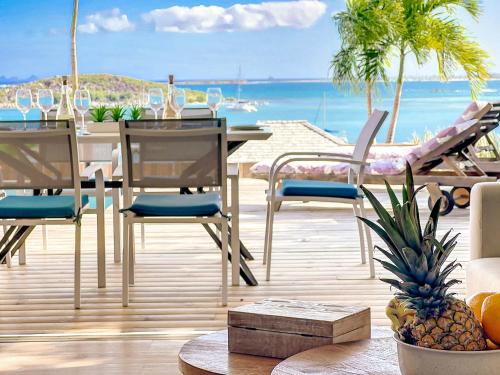 un comedor con mesa y sillas y el océano en Little Paradise 1, 3 bedrooms, private pool, Cul de Sac Bay view en Cul de Sac