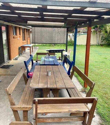 a wooden picnic table with blue chairs and a picnic at The Marlin Place in South West Rocks
