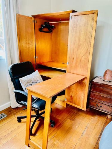 a wooden desk and a chair in a room at Rosehaven on Rosebud in Rosebud