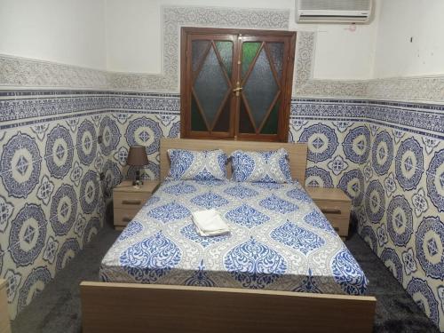 sypialnia z łóżkiem ze wzorzystymi niebiesko-białymi ścianami w obiekcie Calm And Peaceful w Marakeszu