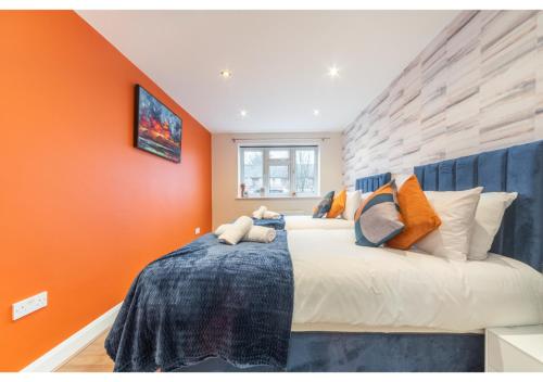 1 dormitorio con 1 cama grande y pared de color naranja en 2 Bedroom Apartment in Perfect Location, en Enfield Lock