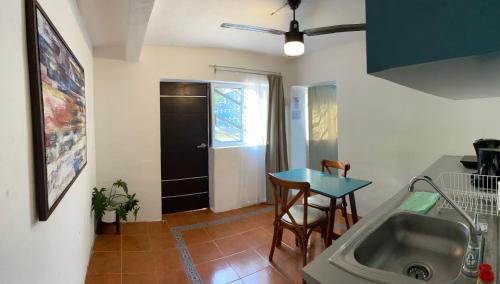 梅里達的住宿－Suites del Sureste - Mérida，厨房配有水槽和桌子
