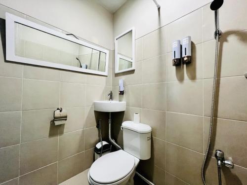 a bathroom with a toilet and a sink and a mirror at Luxury 2BR with Balcony Suite 8 - City View in Manila