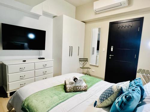 a bedroom with a bed with a tv and a dresser at Luxury 2BR with Balcony Suite 8 - City View in Manila