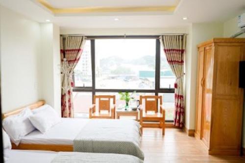 sypialnia z 2 łóżkami i dużym oknem w obiekcie Tiến Khiêm Hotel Lạng Sơn w mieście Lạng Sơn