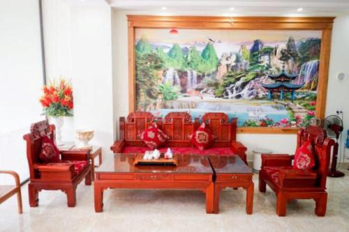 a living room with red furniture and a large painting at Tiến Khiêm Hotel Lạng Sơn in Lạng Sơn