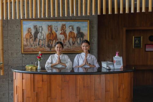 two people sitting at a counter in a room at Taman Mesari Luxury Villas-Seminyak in Seminyak