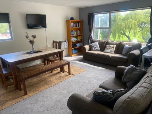 a living room with a couch and a table at Alpine Lodge Queenstown in Queenstown