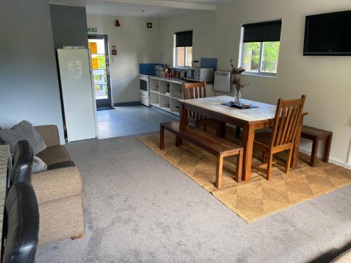 a living room with a table and a kitchen at Alpine Lodge Queenstown in Queenstown