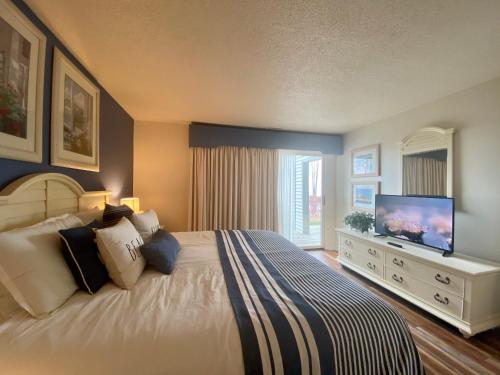 a bedroom with a large bed with a flat screen tv at The Shores in Williamsburg