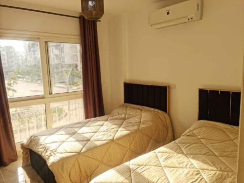 zwei Betten in einem Zimmer mit Fenster in der Unterkunft 3 bed rooms and 2 toilets apartment in Madinty in Madinaty