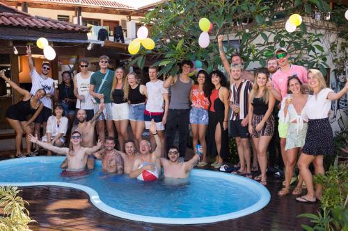 a group of people standing around a swimming pool at Tucano House in Florianópolis