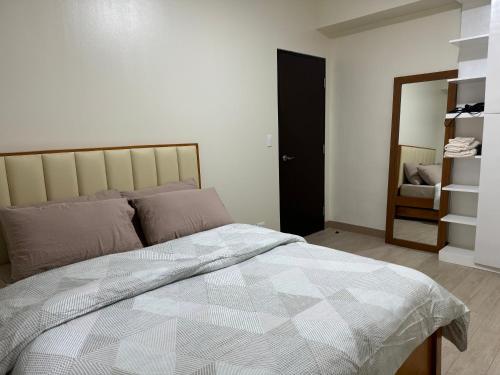 JAZ Stays Bacolod في باكولود: غرفة نوم بسرير كبير ومرآة