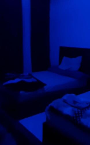 two beds in a dark room with blue lighting at NaserCity، Star in Cairo