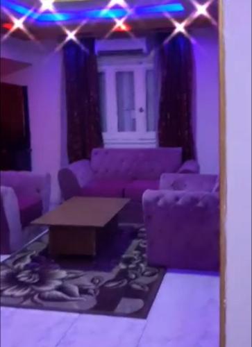 a living room with purple furniture and a mirror at NaserCity، Star in Cairo