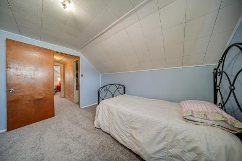 a bedroom with a bed and a wooden door at Ashtabula Home Rental - 2 Mi to Lake Erie, Beaches in Ashtabula
