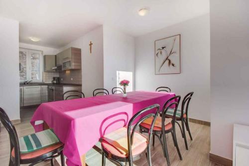 a dining room with a pink table and chairs at Apartment in Cunski - Insel Losinj 15045 in Cunski