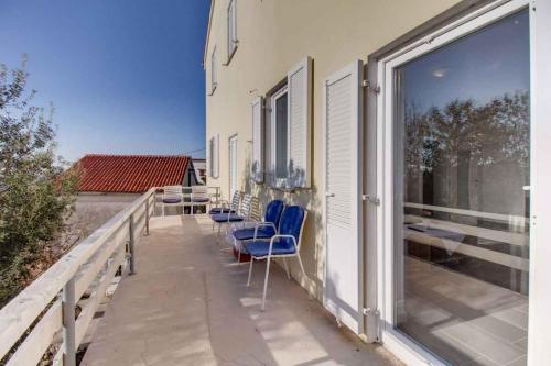 a balcony with chairs and tables on a building at Apartment in Cunski - Insel Losinj 15045 in Cunski