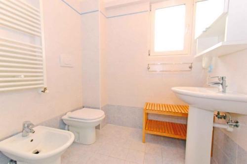 リニャーノ・サッビアドーロにあるApartments in Lignano 21649の白いバスルーム(洗面台、トイレ付)