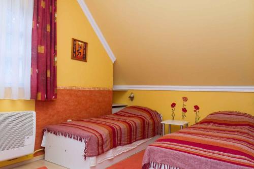 2 Betten in einem Zimmer mit gelben Wänden in der Unterkunft Holiday home in Balatonmariafürdo 19536 in Balatonmáriafürdő