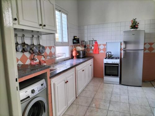 a kitchen with a refrigerator and a dishwasher at Villa Pierrette Casablanca in Casablanca